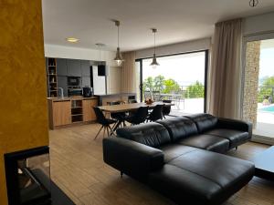 - un salon avec un canapé en cuir noir et une table dans l'établissement Villa Zara Bella Vista, à Kostrena
