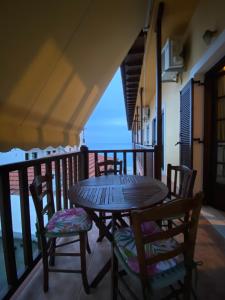 einen Holztisch und Stühle auf dem Balkon in der Unterkunft Amelia Beach Apartments in Agios Ioannis