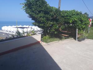 d'une terrasse avec une table et un banc donnant sur l'océan. dans l'établissement Guesthaus Levent, à Trabzon