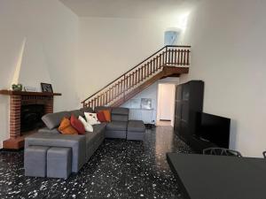 un soggiorno con divano e una scala di Villa Silvia, indipendente con giardino privato e garage a Varazze