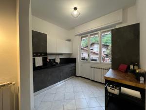 uma cozinha com balcões a preto e branco e uma janela em Villa Silvia, indipendente con giardino privato e garage em Varazze