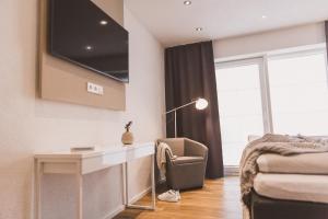 a living room with a desk and a tv on the wall at Weingut Gehlen-Cornelius in Brauneberg