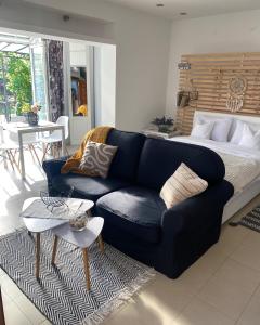 a living room with a blue couch and a bed at Green garden in Žarkovo