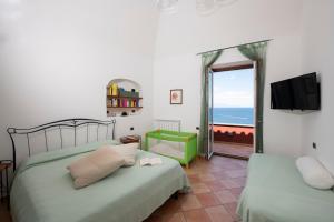 a bedroom with two beds and a view of the ocean at Il Sogno di Conca in Conca dei Marini