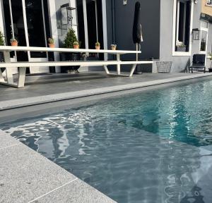 a swimming pool with a white railing next to a building at La Villa 1901 in Nancy