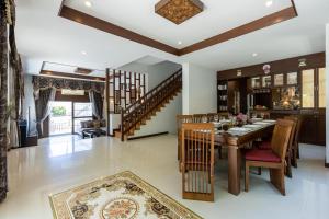 a dining room with a table and chairs and a staircase at 5 Bedroom Pool Villa Close To Town H5 in Hua Hin