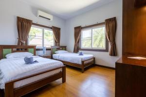 a bedroom with two beds and two windows at 5 Bedroom Pool Villa Close To Town H5 in Hua Hin +72 photos