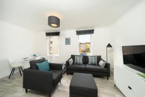 a living room with two couches and a tv at The Doric in Aberdeen