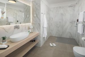 a white bathroom with a sink and a toilet at Maj Luxury Residence in Poreč
