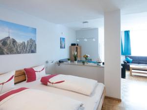 a bedroom with a bed and a living room at Appartementhaus Angelika in Lindau
