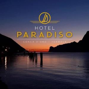 een bord voor een hotel parabel zittend in het water bij Hotel Paradiso Conca d'Oro in Nago-Torbole
