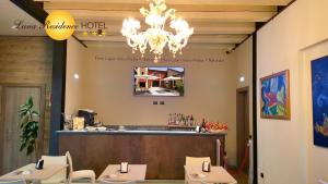 a restaurant with a bar and a chandelier at Luna Residence Hotel in Casalmaggiore