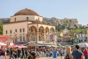 una multitud de personas caminando por un mercado frente a un edificio en Monastiraki #507 by SuperHost Hub AcropolisView en Athens