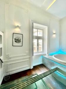 a bathroom with a tub and a window at Enzo Capo Andrassy Avenue in Budapest
