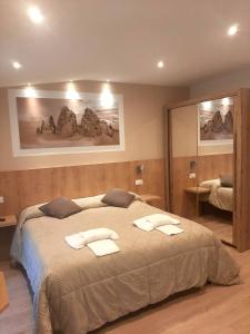 1 dormitorio con 1 cama grande y toallas. en Albergo Vittoria, en Santo Stefano di Cadore