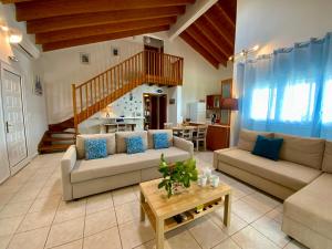 a living room with two couches and a staircase at Villa Azure in Skiathos