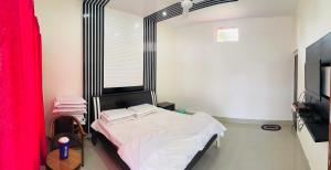 1 dormitorio con 1 cama con cortina roja en Kanva Farms, en Kotdwāra