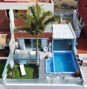 an aerial view of a house with a swimming pool and a palm tree at Villa con piscina privada Palmeras Home in Las Palmas de Gran Canaria