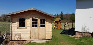 a small wooden shed with a playground in the background at Ubytování u Kotrbů in Suchdol nad Lužnicí