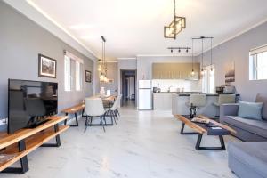 a living room with a couch and tables and a kitchen at Oreon Suites - Usia in Nafplio