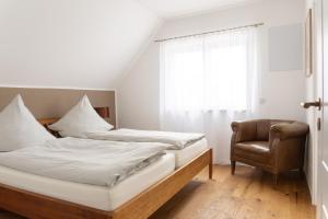 - une chambre avec un lit, une chaise et une fenêtre dans l'établissement Design Wohnung `Eiche´ auf dem Bodanrück, à Radolfzell am Bodensee