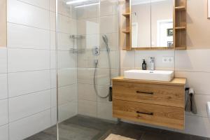 a bathroom with a sink and a shower at Design Wohnung `Eiche´ auf dem Bodanrück in Radolfzell am Bodensee
