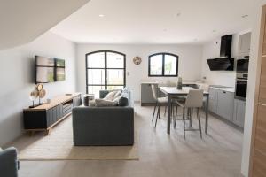 a kitchen and living room with a couch and a table at MAISON LAVANDE du MAS LOU CAPY in Salon-de-Provence