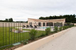 une clôture en face d'une maison avec piscine dans l'établissement MAISON LAVANDE du MAS LOU CAPY, à Salon-de-Provence