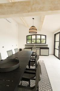 a dining room with a black table and chairs at MAISON LAVANDE du MAS LOU CAPY in Salon-de-Provence