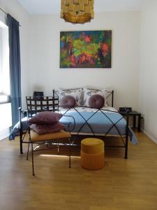 a bedroom with a bed and a painting on the wall at Künstler-Villa Ambrosian Apartment Magnolia in Trzebież