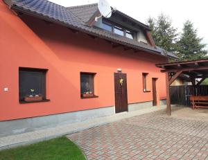 uma casa vermelha com uma porta castanha e janelas em Ubytovanie v Lihôtke em Oravský Podzámok