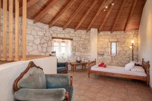 a living room with a couch and chairs in a building at Gerakomylos Stone House in Vasilikos