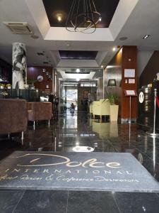 a restaurant with a dining area with a sign on the floor at Hotel Dolce International in Skopje