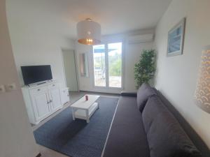 een woonkamer met een bank en een tafel bij La terrasse de l'Imbut - Climatisation & Piscine in Gréoux-les-Bains