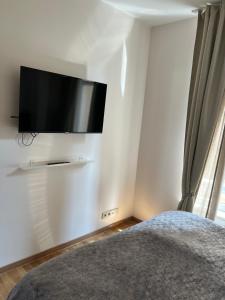 um quarto com uma televisão de ecrã plano na parede em Cosy appartement with canal view em Bruxelas