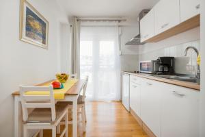 a kitchen with white cabinets and a table with fruit on it at Apartment Mares in Split