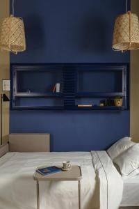 een blauwe slaapkamer met een bed en een tafel bij City Garage Studio - Lwowska 9 in Warschau