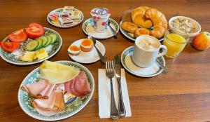 a table with plates of breakfast foods and cups of coffee at Hotel Turnerwirt in Salzburg