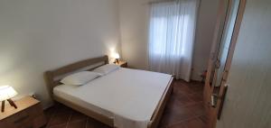 sypialnia z białym łóżkiem i oknem w obiekcie Ancora Prcanj w Kotorze