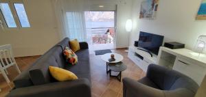 salon z niebieską kanapą i telewizorem w obiekcie Ancora Prcanj w Kotorze