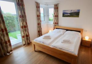 sypialnia z łóżkiem i dużym oknem w obiekcie Appartements Julia w mieście Zell am See