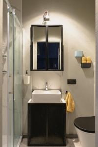 een badkamer met een wastafel en een spiegel bij City Garage Studio - Lwowska 9 in Warschau