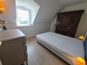 um quarto com uma cama, uma cómoda e uma janela em REF 035 - Belle maison en pierre pour quatre personnes proche Golfe du Morbihan ARZON em Arzon