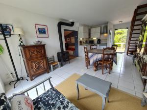 uma sala de estar com uma mesa e uma sala de jantar em REF 035 - Belle maison en pierre pour quatre personnes proche Golfe du Morbihan ARZON em Arzon