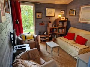 uma sala de estar com dois sofás e uma estante de livros em REF 035 - Belle maison en pierre pour quatre personnes proche Golfe du Morbihan ARZON em Arzon