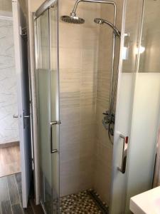 a shower with a glass door in a bathroom at L’annexe in Lunéville