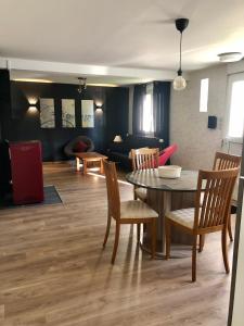 a living room with a table and chairs and a couch at L’annexe in Lunéville