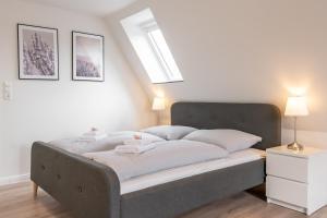 sypialnia z dużym łóżkiem z białą pościelą w obiekcie Landschaftliches Haus w mieście Tönning