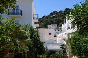 a white building with palm trees in front of it at La Residenza Capri in Capri