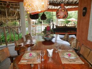 einen Holztisch mit Tellern und Weingläsern darauf in der Unterkunft Villa Ndoto in Diani Beach